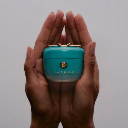 Hands holding the Tatcha Longevity Memory Cream